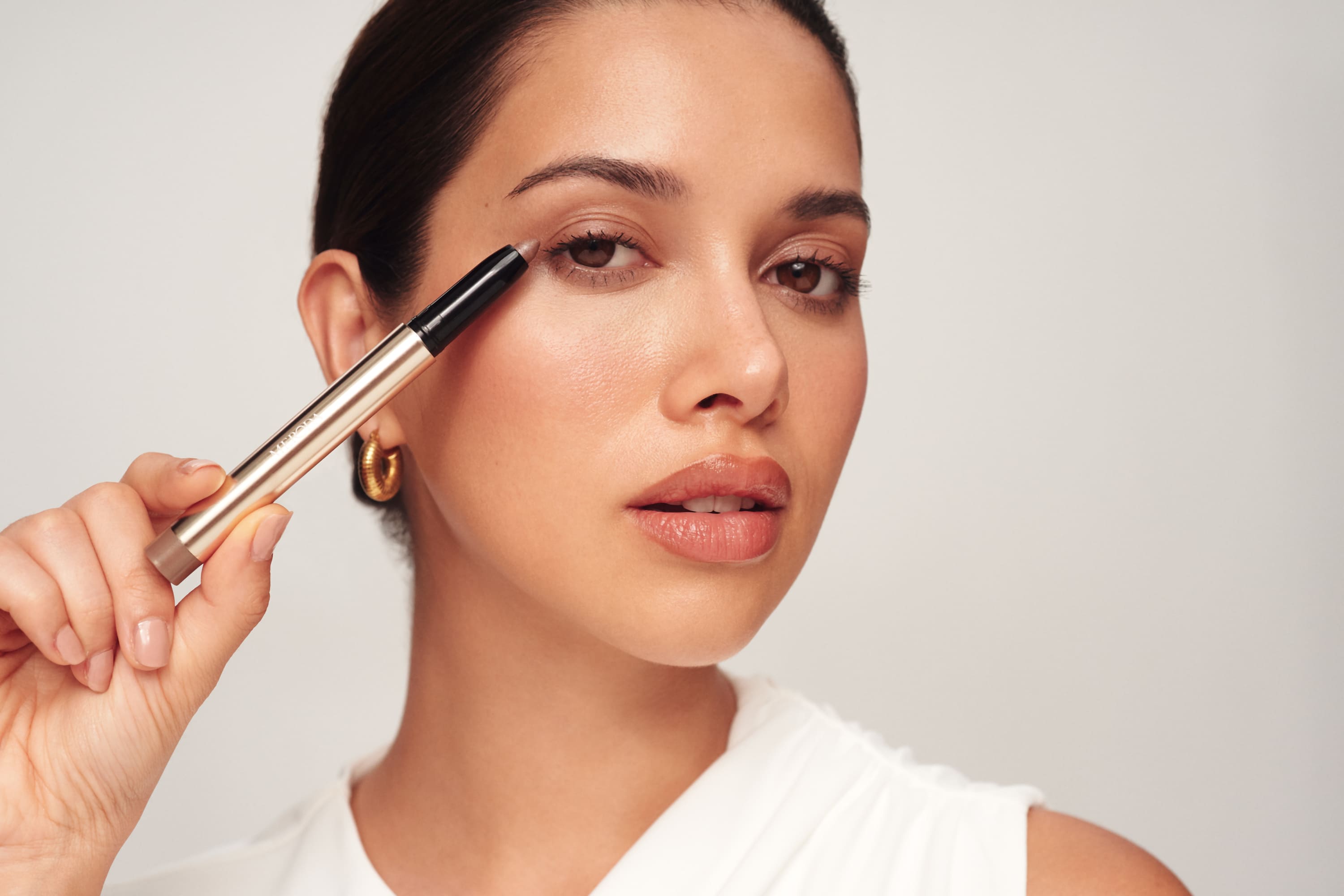 Woman holding a eye shimmer stick
