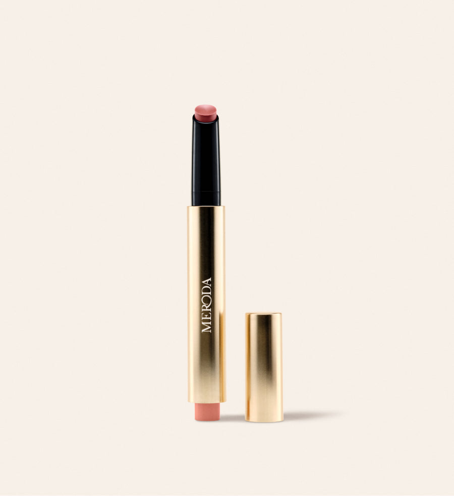 Hydrating Lip Tint in Dusty Rose: een slanke gouden klikpen met open dop op een crème achtergrond.