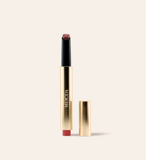 Hydrating Lip Tint in Rich Berries, een gouden metallic klikpen met losse dop en bessenkleurige balsem op crème.