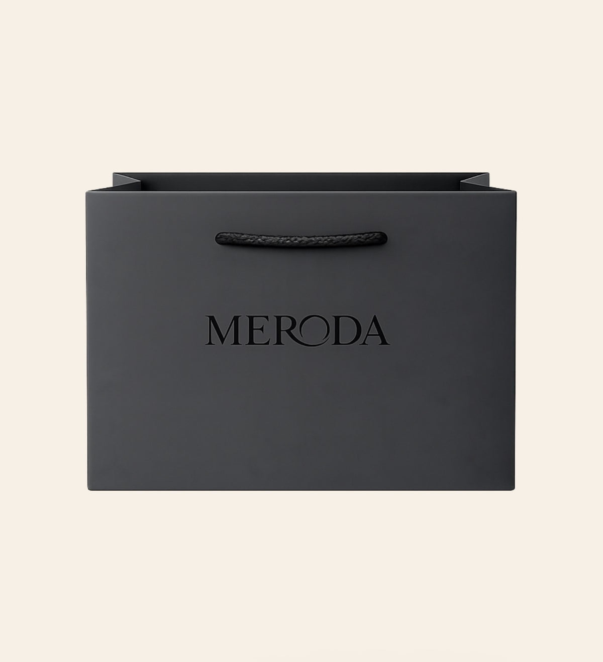Matte zwarte Cadeautas met een geweven touwvatting en een in relief gedrukt Meroda logo op een creme achtergrond