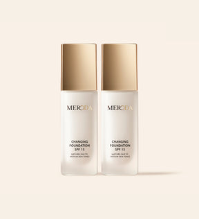 Twee Meroda Changing Foundation flacons met gouden dop naast elkaar op een neutrale achtergrond