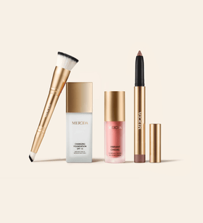 The Daily Routine Set met 2-in-1 Build & Conceal Brush, Changing Foundation SPF 15, Vibrant Cheeks Liquid Blush en Eye Perfecting Shimmer Stick op een lichte achtergrond