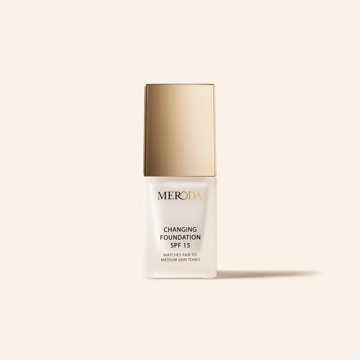 Meroda Mini Changing Foundation met SPF 15 in een witte flacon met gouden dop voor lichte tot medium huidtinten