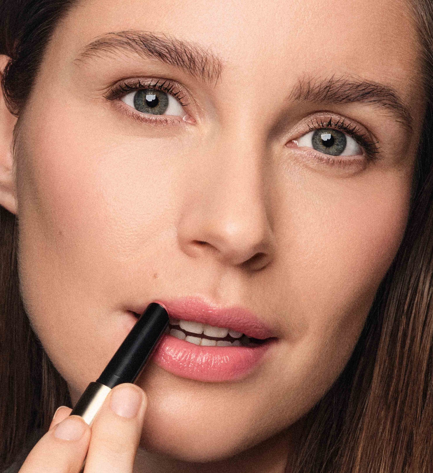Hydrating Lip Tint in Peachy Rose aangebracht op de lippen van een model voor een natuurlijke glans.