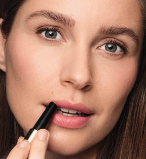 Hydrating Lip Tint in Peachy Rose aangebracht op de lippen van een model voor een natuurlijke glans.