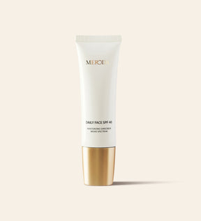 Daily Face SPF 40 hydraterende zonnebrandcrème in een slanke witte tube met een metallic gouden dop.