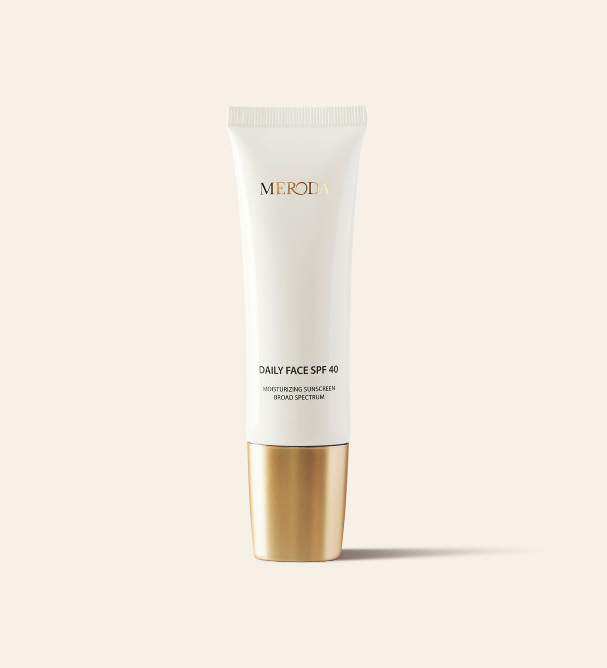 Daily Face SPF 40 hydraterende zonnebrandcrème in een slanke witte tube met een metallic gouden dop.