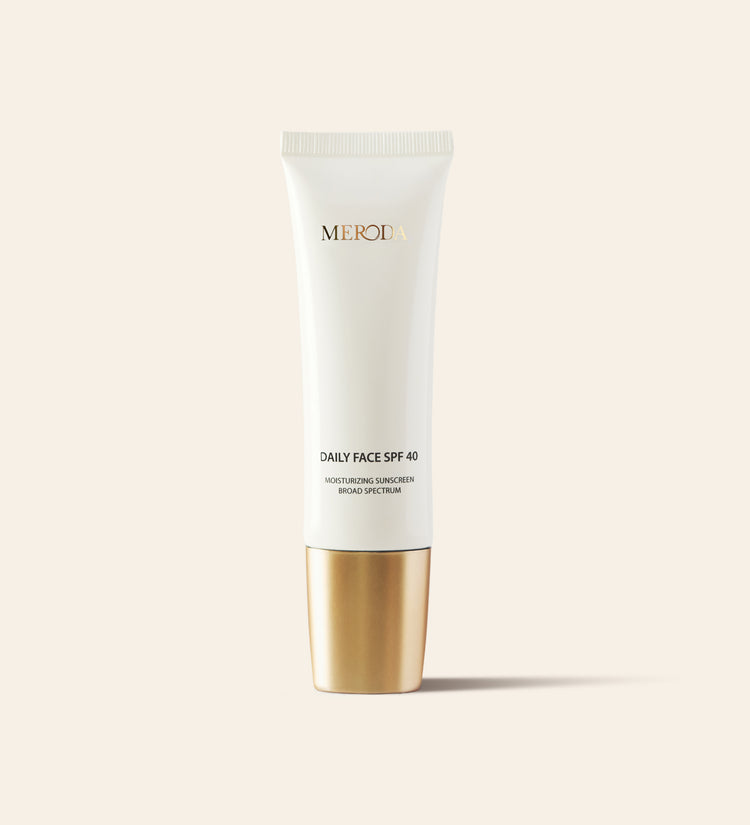 Daily Face SPF 40 hydraterende zonnebrandcrème in een slanke witte tube met een metallic gouden dop.