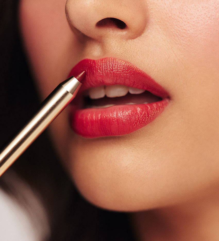 Model dat Signature Lip Pencil in Luscious Red uit de Luscious Lips Set aanbrengt