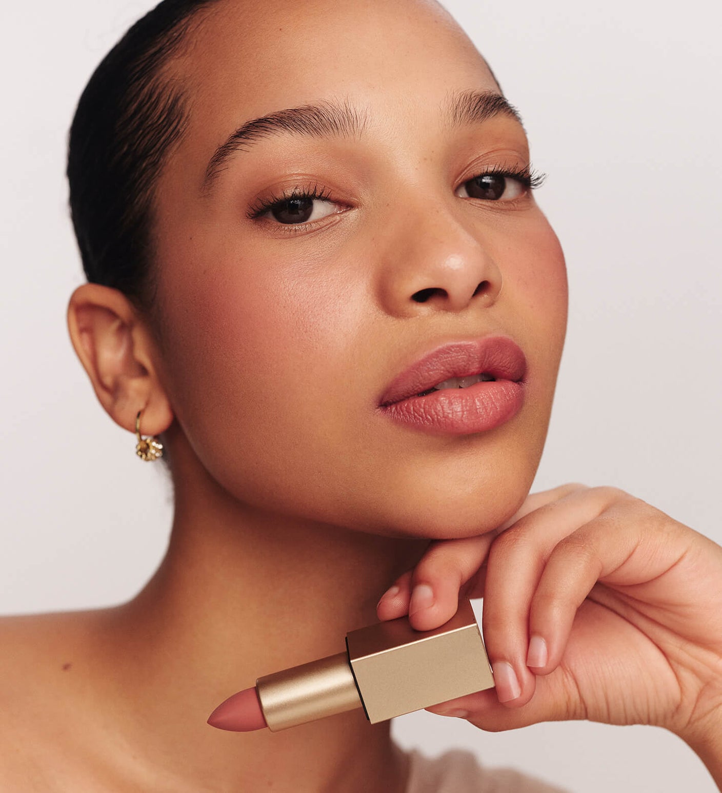 Velvet Dream Lipstick in Perfect Nude vastgehouden door model die een luxe matte finish laat zien