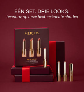 Mini Lip Tint Trio met drie hydraterende tinten in elegante gouden verpakking op een bordeauxrode achtergrond.