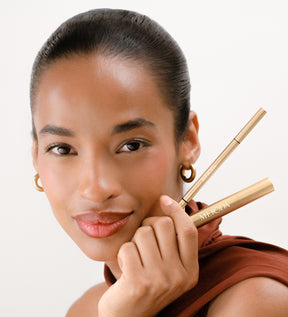The Brow Defining Duo met The Precision Brow Pencil en The Precision Brow Gel vastgehouden door een model