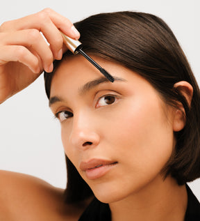Vrouw die Meroda The Precision Brow Gel aanbrengt om wenkbrauwen in model te brengen en te fixeren voor een natuurlijke look